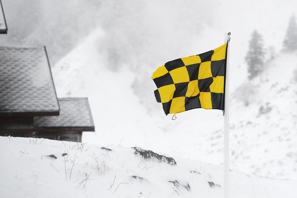 "Que signale le drapeau à damiers noir et jaune dans une station de sports d'hiver ?"
