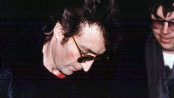 Sur ce cliché, à qui John Lennon signe-t-il un autographe ?