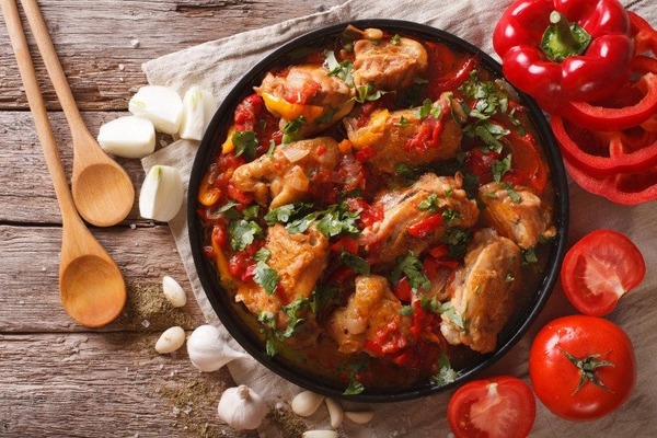 Spécialité culinaire typique du Pays Basque, le poulet basquaise se compose de morceaux de poulet, de tomates et de :