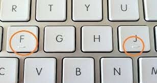 Les petits traits en relief sur les touches "F" et "J" d'un clavier d'ordinateur _____