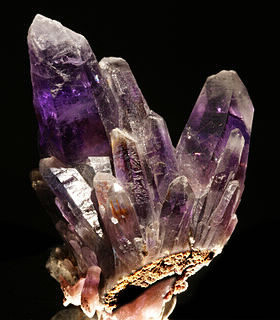 La couleur de cette pierre est violette et la plupart des ces pierres se décolorent à partir d'une certaine température. Quel est son nom ?