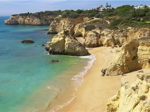 A Praia dos Beijinhos é uma praia algo frequentada de areia branca protegida por penedos... onde se localiza?