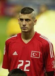 Ancien international turc ayant joué au Galatasaray et brièvement au Milan AC début des années 2000, ici à la coiffe d'Iroquois.