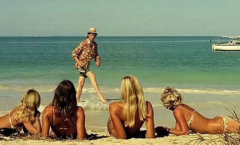 Dans quel film Aldo Maccione apprend-il à ses camarades à frimer devant les filles en marchant sur la plage ?