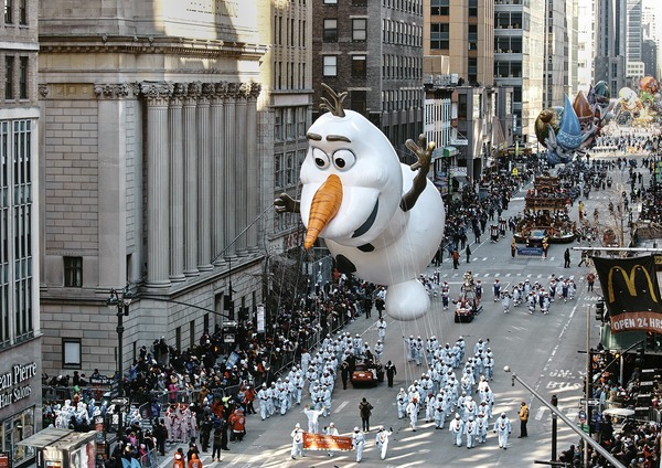 What do represent the floats and the giant balloons of the macy's parade ?