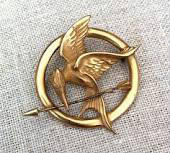 Quel est l'animal qui est représenté sur la broche de Katniss ?