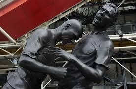 Qui sont les deux joueurs de foot représentés sur la statue ?