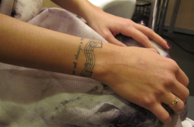 Quelle partition de musique a-t-elle tatoué sur le poignet gauche ?